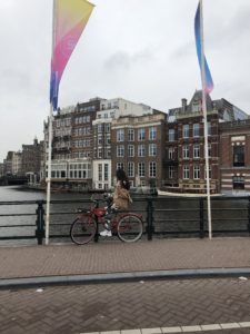 Girl on a bicycle exploring the canals of Amsterdam City