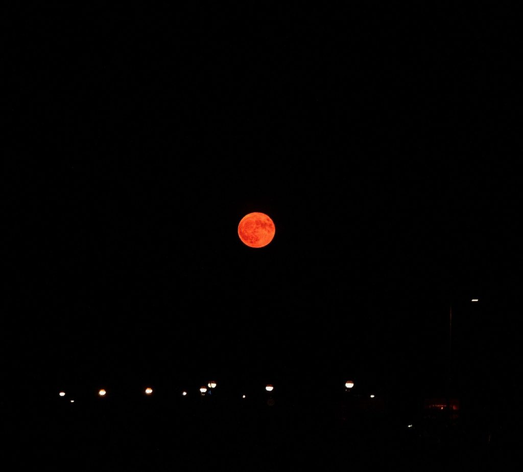 The moon with a strong orange hue, completely altering its appearance.