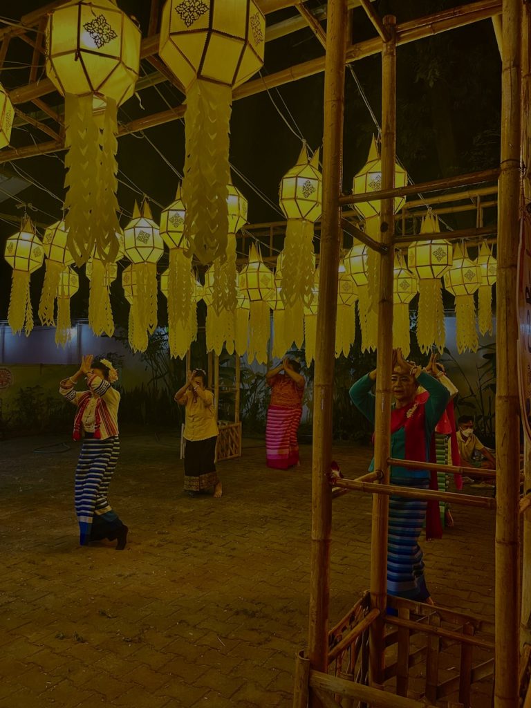 Traditional Thai dancing beneath yellow paper lanterns.