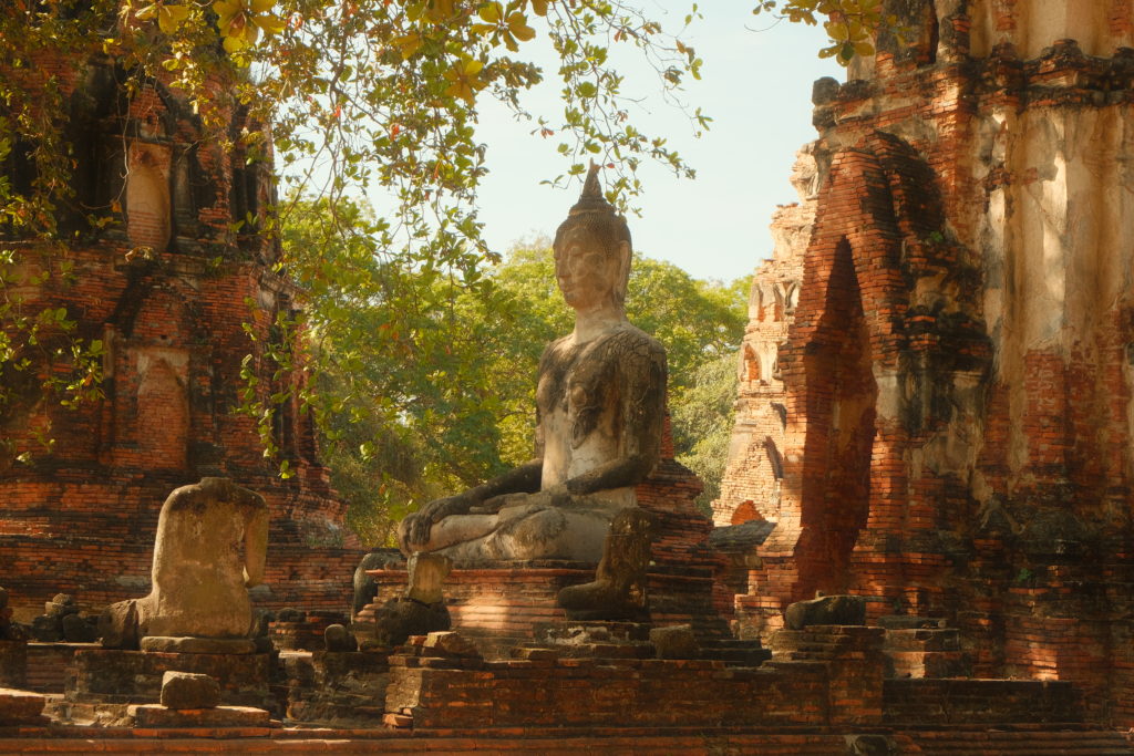 A Buddha statue within the ancient ruins of Wat Phra Mahathat, Ayutthaya.