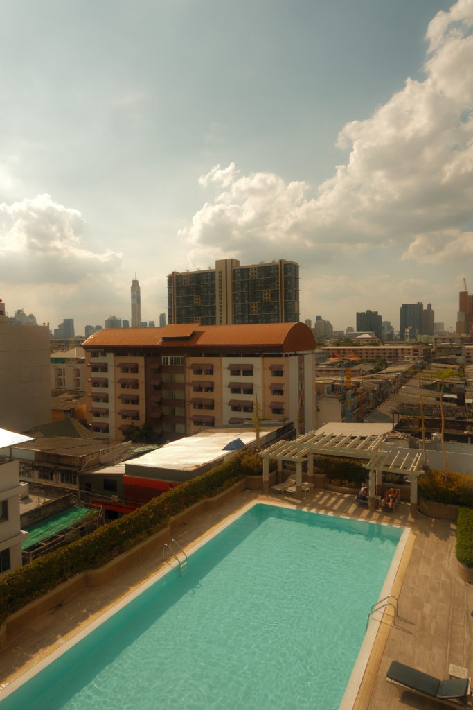 An outside pool with views of Bangkok City.