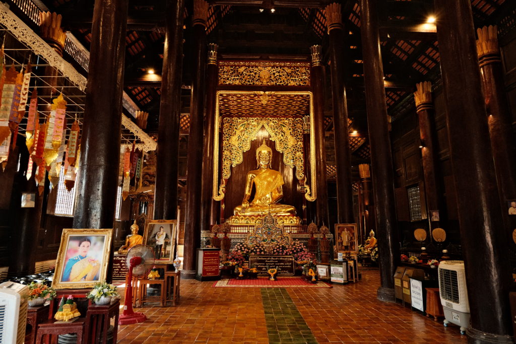 A look inside a Buddhist temple, with dark wooden decor.