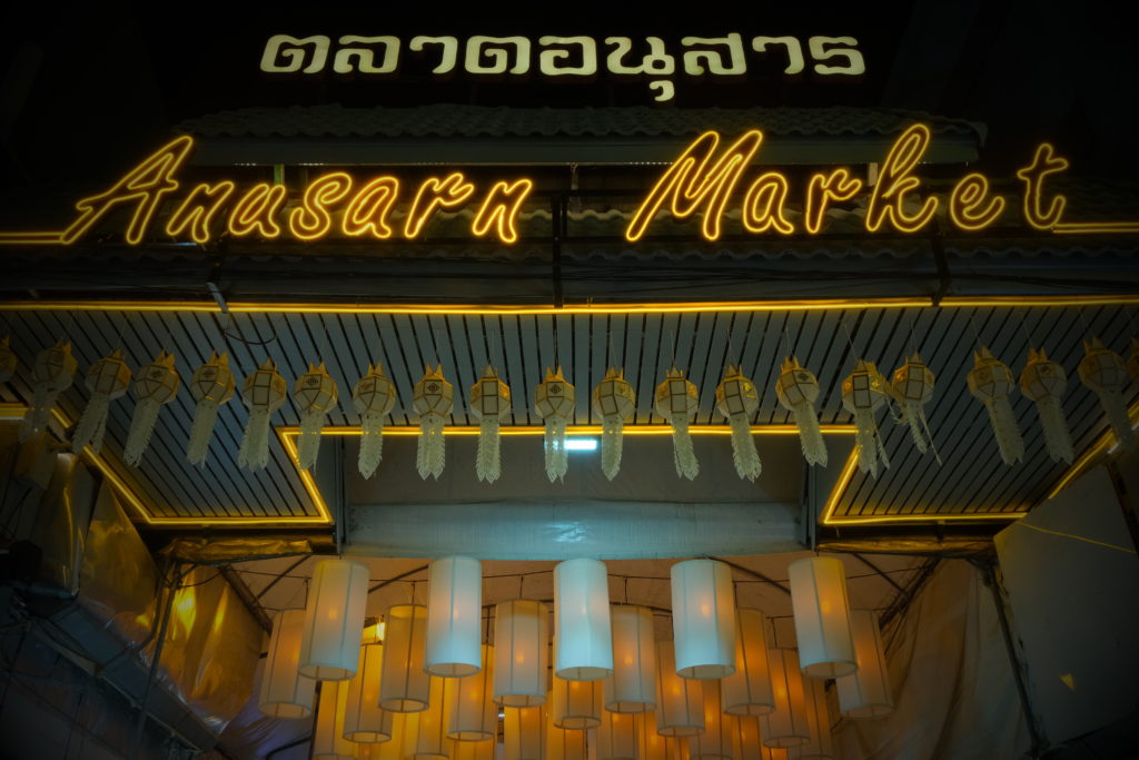 An entrance to a night market, decorated with glowing lanterns.