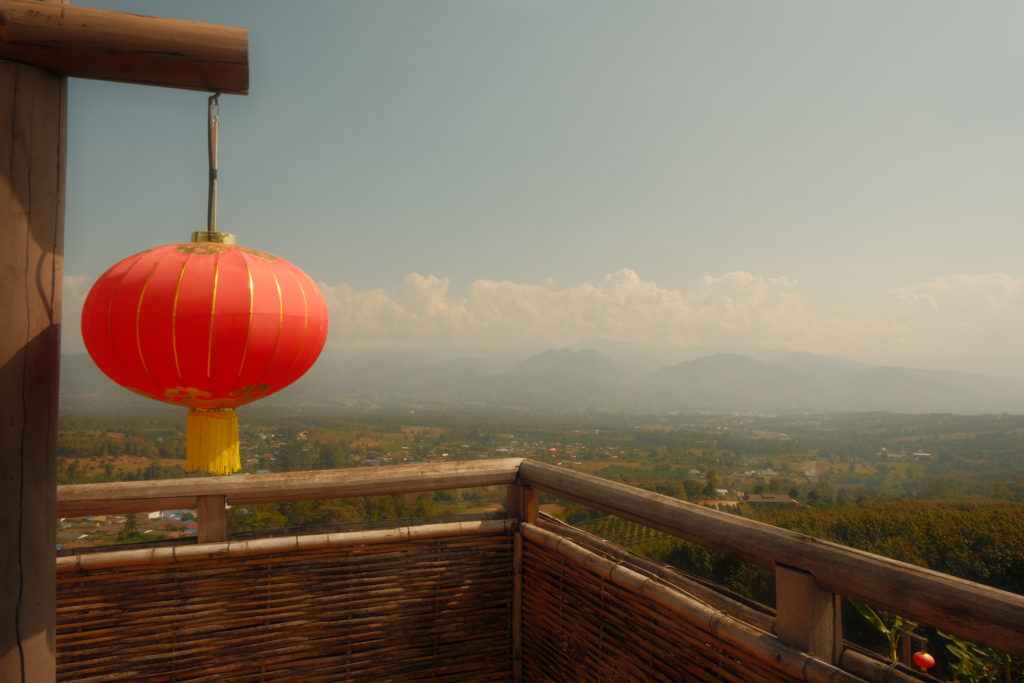A red lantern in front of a beautiful panoramic view across the valley of Pai.