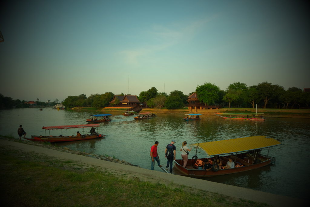 Longtail boats situated on a peaceful countryside river in Thailand.