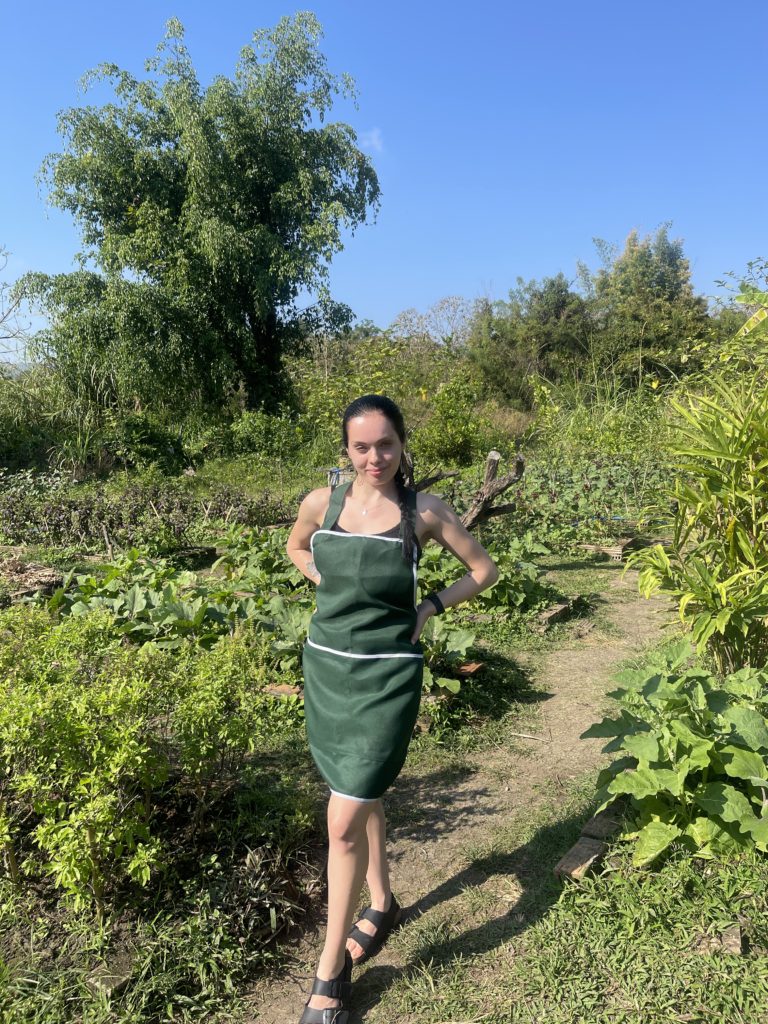 A girl in an apron at a local farm during a cooking class.