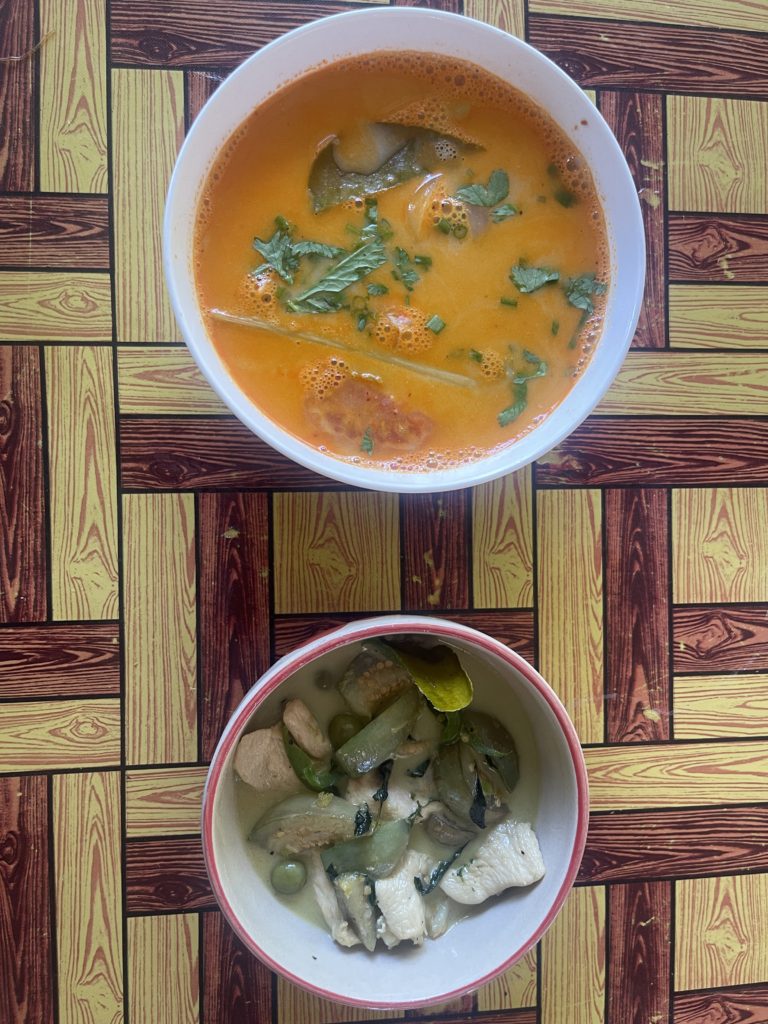 A hot and creamy soup alongside a green thai curry.