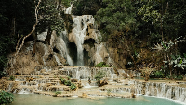 Kuang Si Waterfall in Laos, a picturesque natural wonder surrounded by lush greenery and cascading waters.