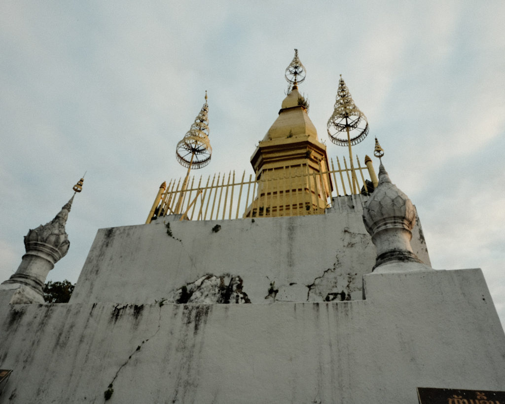 A white and gold temple on top of a mountain.