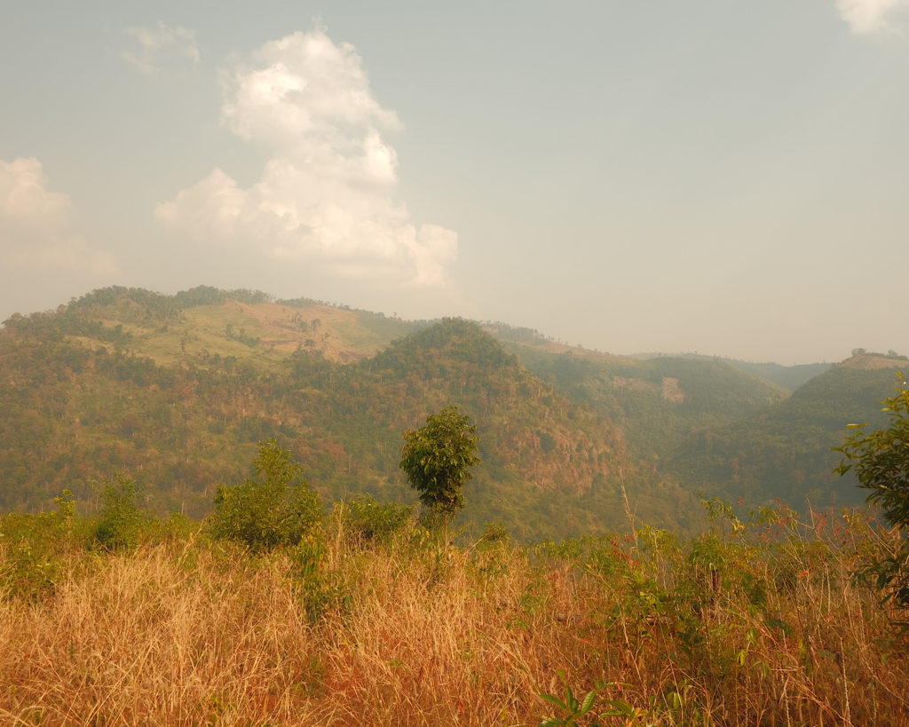 A mountainous view with lush greenery on a dry and hot day.