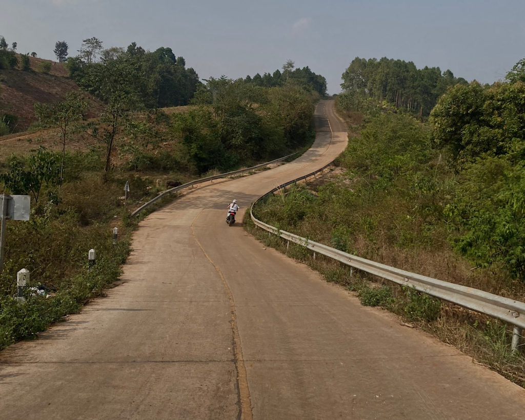 A long winding road through lush greenery in the mountains.