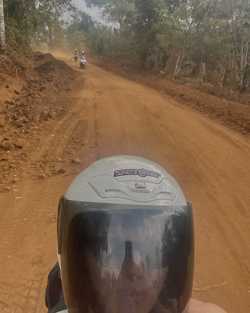 Motorbikes on a dusty dirt road.