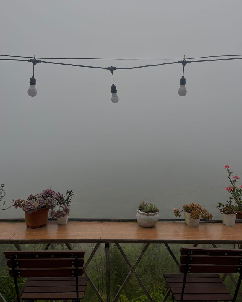 A breakfast bar overlooking rice fields surrounded by fog.