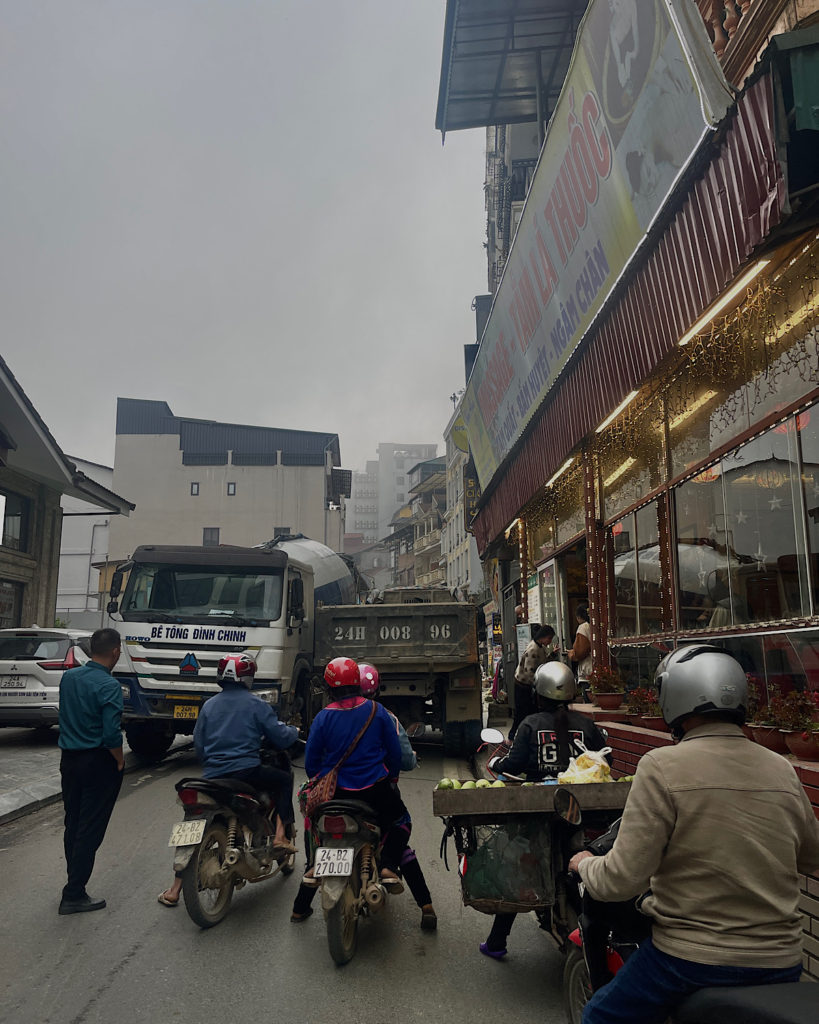 A busy road in Sapa with many people travelling by motorbike.