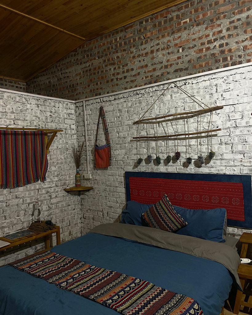 Cozy bedroom with brick walls and bohemian decor.