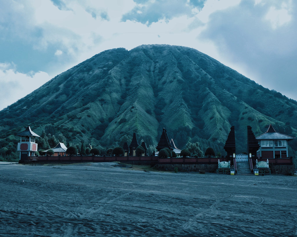 A Hindu temple situated in the black sea of sand at Mount Bromo.