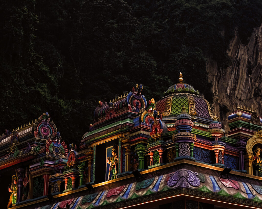 A vibrant temple featuring intricate and colourful decorations adorning its roof, showcasing cultural artistry.