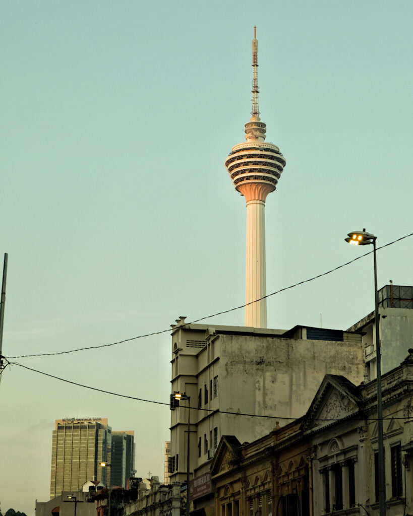 A tall tower showcasing its height amongst other buildings in the city.