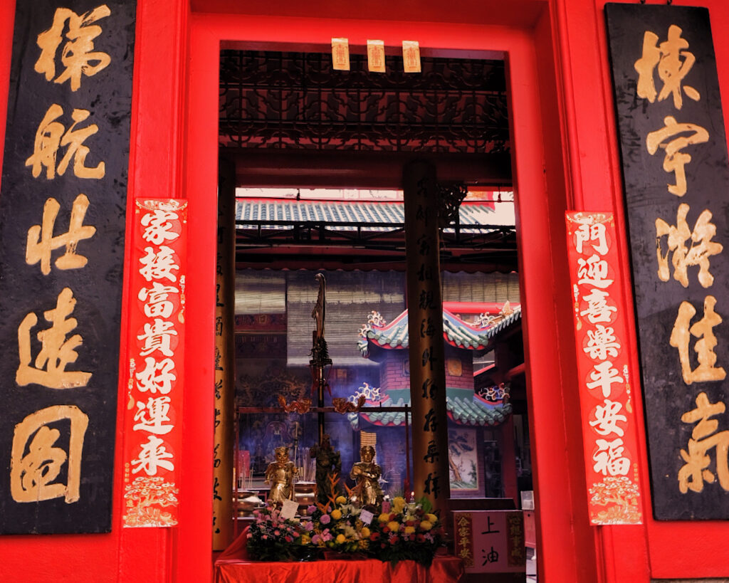 A red door adorned with Chinese characters and elegant gold decorations, showcasing cultural artistry and vibrant colour.